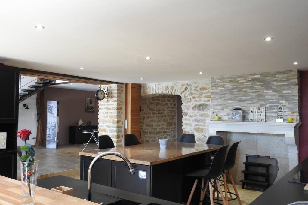 une cuisine et un salon avec une table et des chaises dans l'établissement Magnifique corp de ferme rénové, à Changey