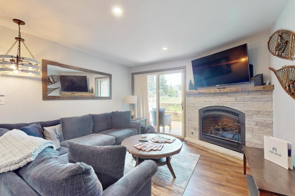 een woonkamer met een bank en een open haard bij Beaver Creek Bungalow in Avon