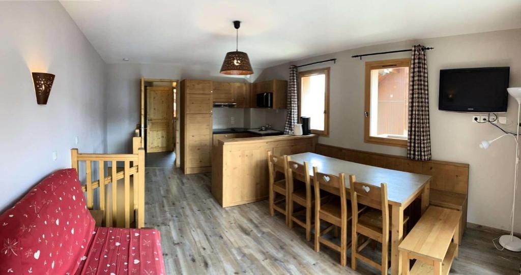 Il comprend une cuisine et une salle à manger avec un canapé rouge. dans l'établissement Chalet Des Rennes - Super duplex résidence de standing au pied des pistes MAE-9951, à Vars
