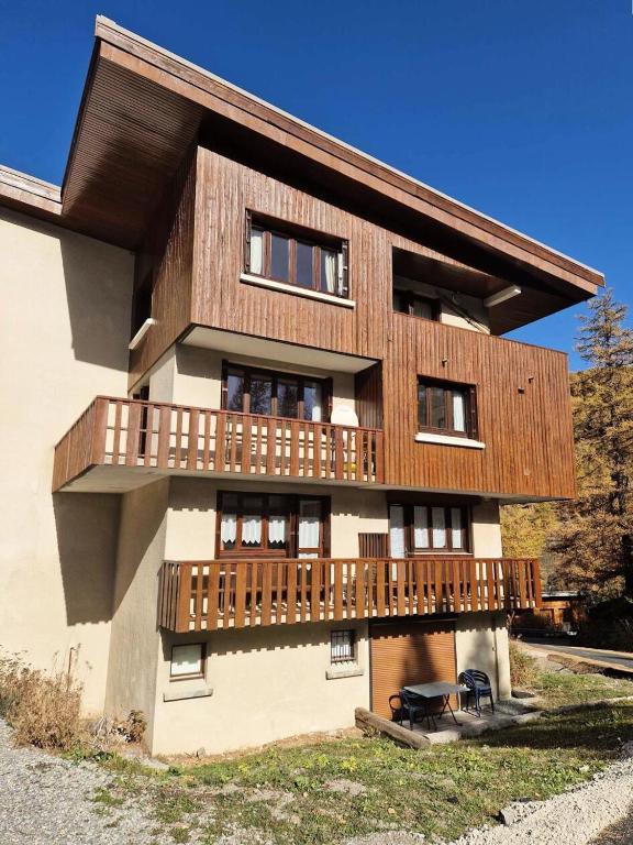 une maison avec un balcon en bois sur le côté dans l'établissement Résidence Gaubert - Mignon petit studio 4 couchages à Vars MAE-9981, à Vars