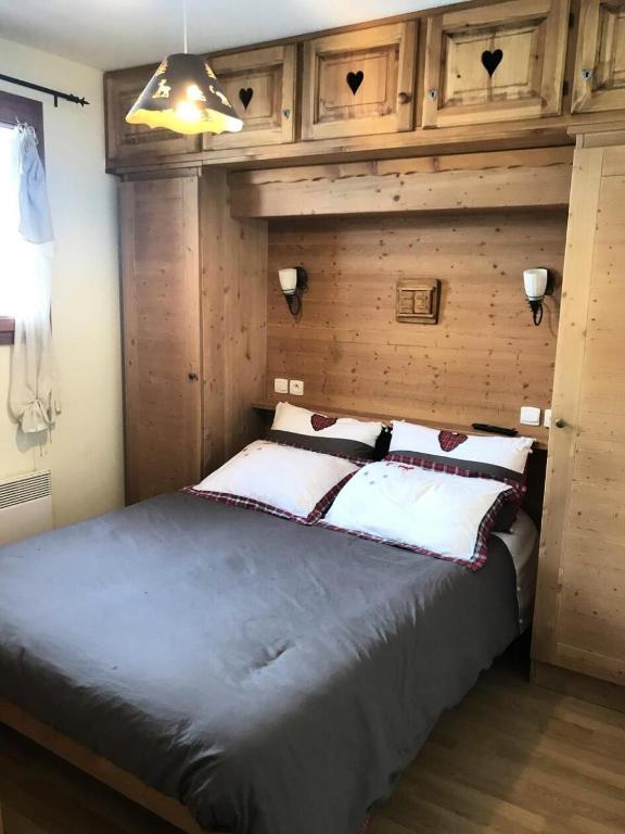 une chambre avec un grand lit avec un mur en bois dans l'établissement Chalet Des Rennes - Appart tout confort plein sud dans résidence de standing & garage au pied des pistes MAE-0001, à Vars