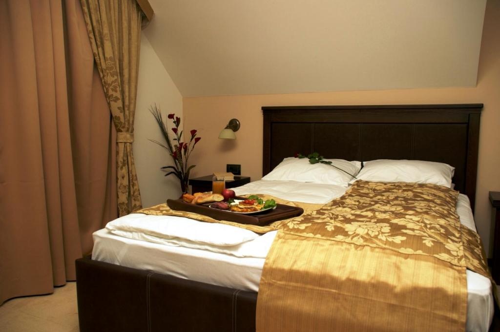 a hotel room with a bed with a tray of food on it at Vila Pina in Zlatibor