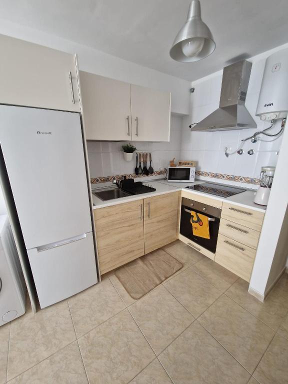 a kitchen with white cabinets and a white refrigerator at APARTAMENTO EL RINCÓN in La Restinga