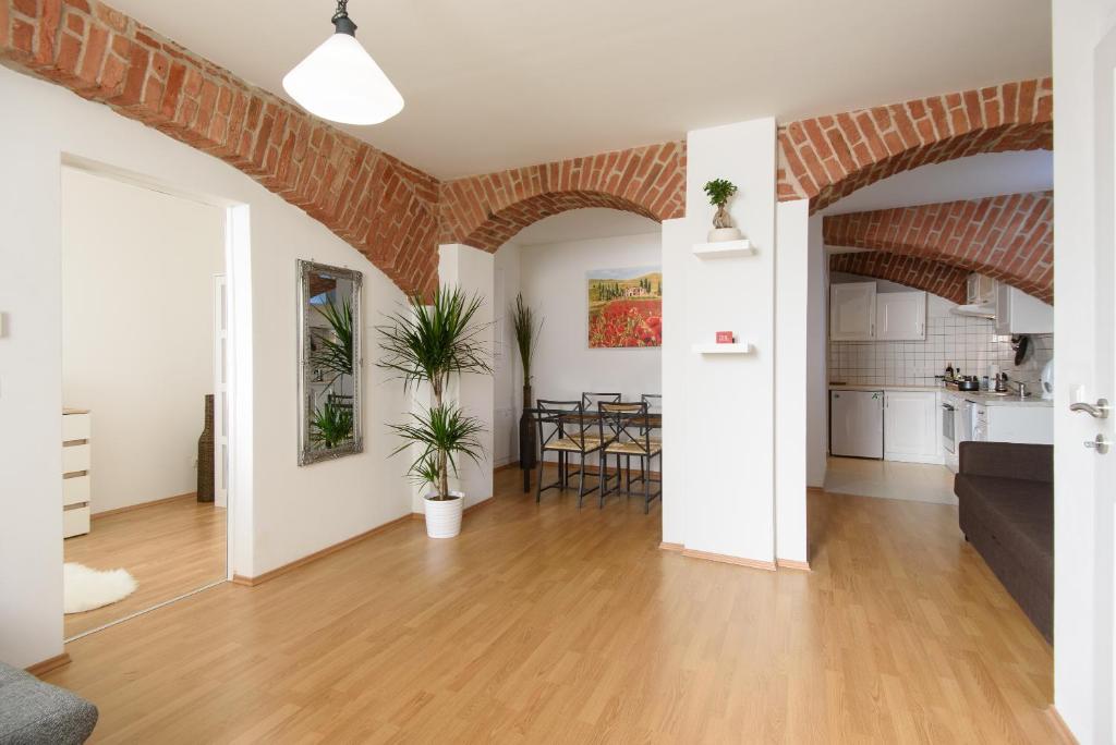 a living room with a wooden floor and a brick wall at Vienna Living Apartments - Währing in Vienna