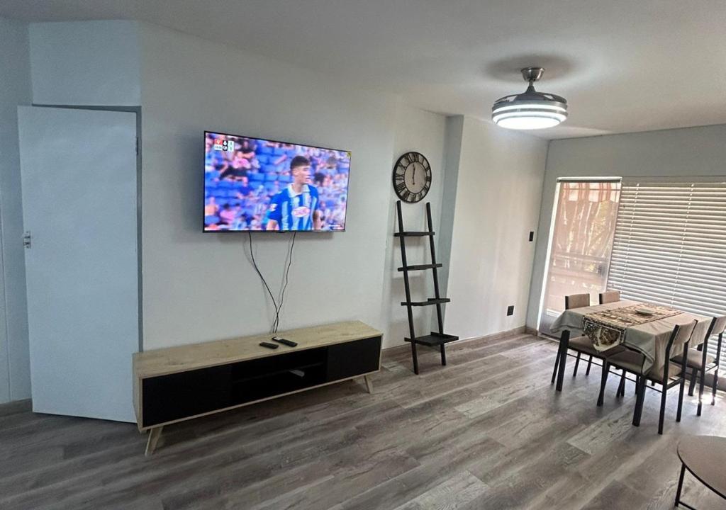 a living room with a tv on a wall at Entire Apartment in Eldoraigne, Centurion in Eldoraigne