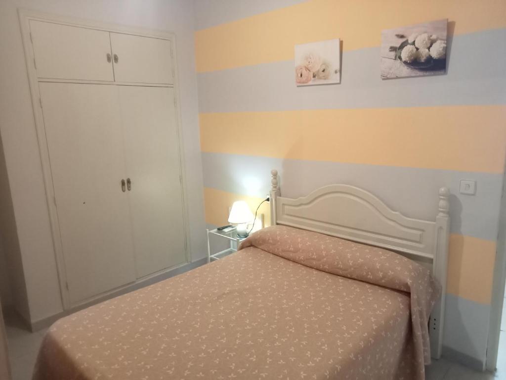 トルヒーリョにあるHostal Trujilloの小さなベッドルーム(ベッド1台、キャビネット付)