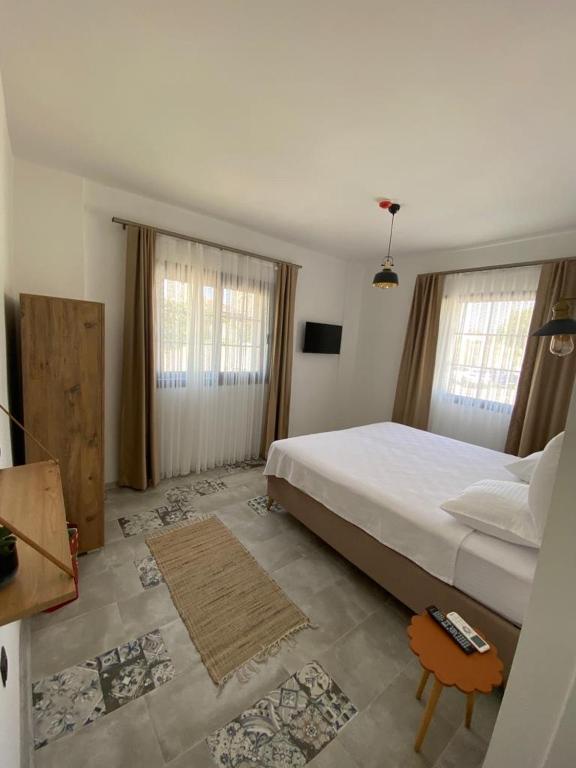 a bedroom with a large white bed and windows at La Chance Alaçatı in Alaçatı