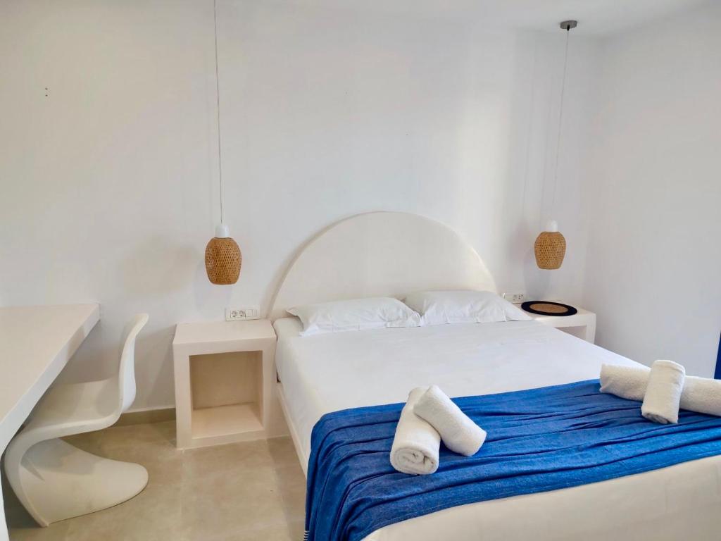 a white bedroom with a bed with towels on it at Casa Kallisti Suites in Pirgos