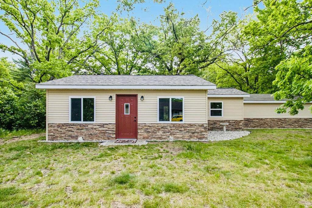 a house with a red door in a yard at School Section Cottage Lake Access in Mecosta