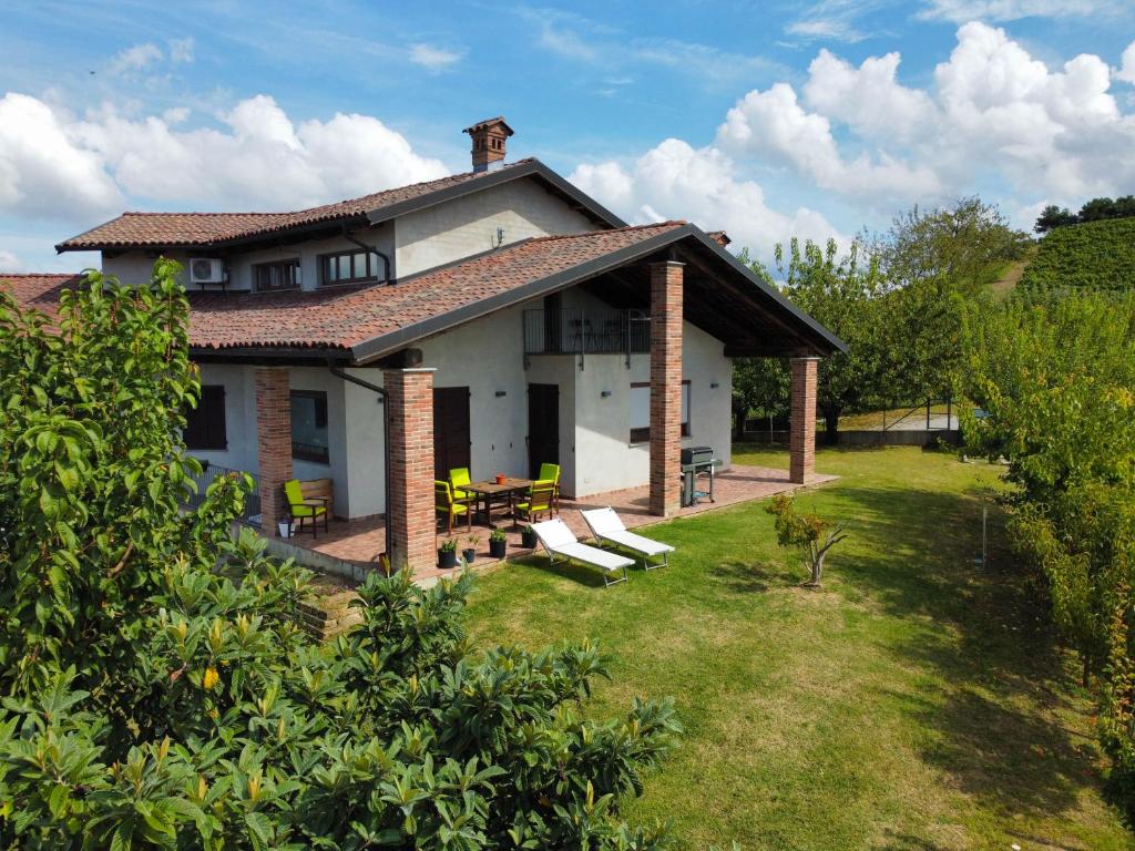 a house with a patio and some chairs and tables at Il Girasole Apartments - Langhe in Treiso
