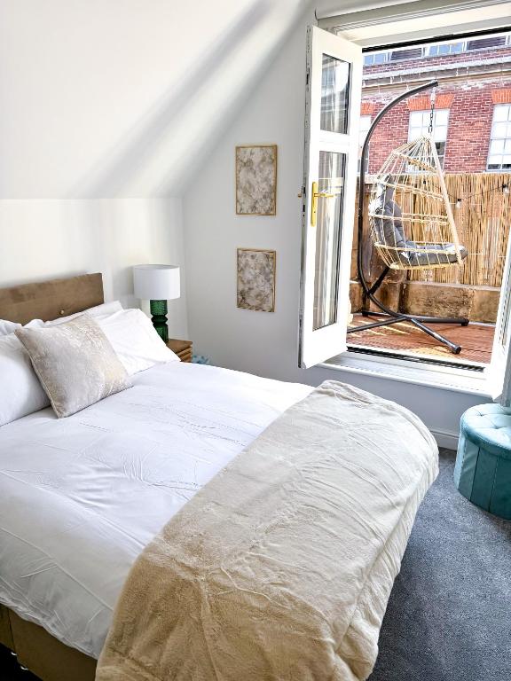 a bedroom with a white bed and a window at The Luxe Haven Penthouse - Sleeps 4 Apartment Nottingham City Centre in Nottingham