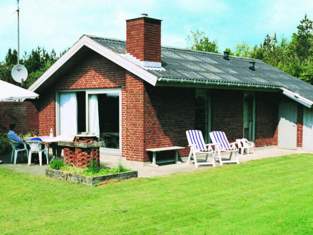 una casa de ladrillo rojo con sillas y mesa en Cozy Retreat near Marielyst - By Traum Ferienwohnungen, en Bøtø By