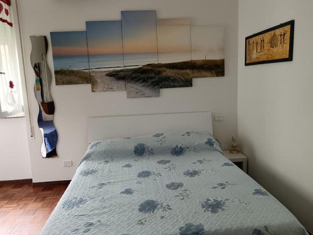 una camera da letto con un letto e dipinti alle pareti di Casa Vacanze Stella Maris Vasto Marina centro a Vasto