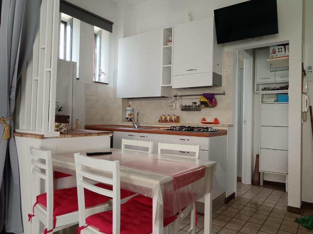 una cucina con mobili bianchi, tavolo e sedie di Casa Vacanze Stella Maris Vasto Marina centro a Vasto