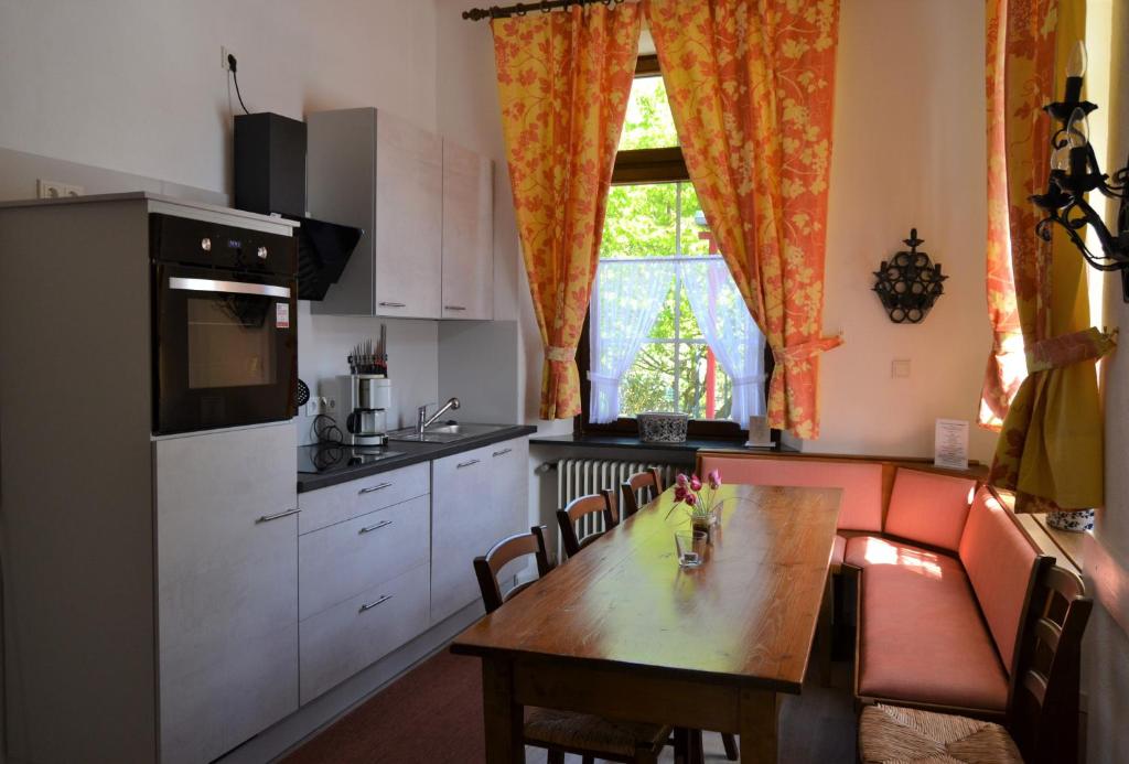 a kitchen with a wooden table and a kitchen with a tableablish at Ferienwohnungen am Stadtpalais - Bernkastel in Bernkastel-Kues