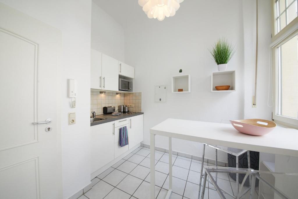 a white kitchen with a counter and a table at Ferienwohnungen am Gestade Wohnung 3 in Bernkastel-Kues