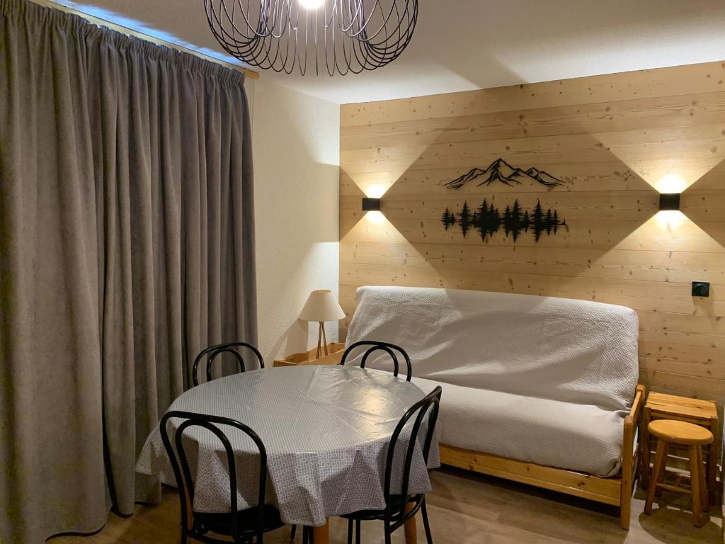 une chambre avec un lit et une table avec des chaises dans l'établissement Charmant appart 2P cabine, rénové, balcon, parking gratuit, pied des pistes - FR-1-755-22, à Aime La Plagne