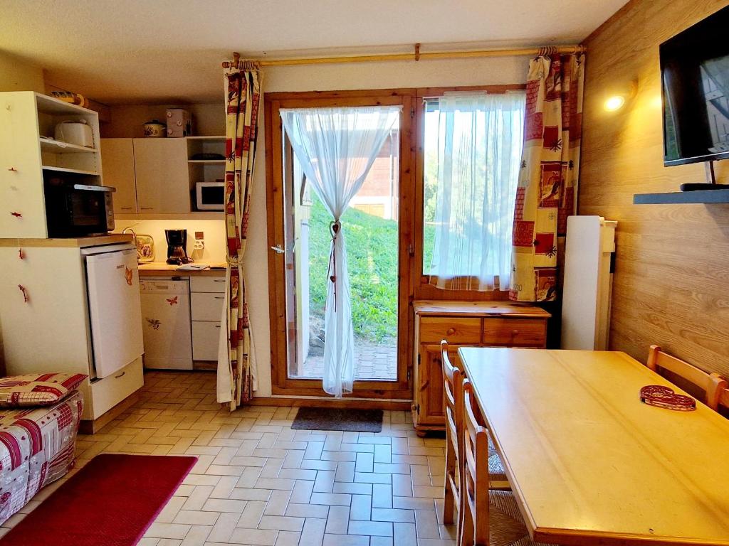 a kitchen with a table and a sliding glass door at Charmant T2 avec terrasse, proche pistes, parking gratuit - FR-1-755-21 in Aime La Plagne