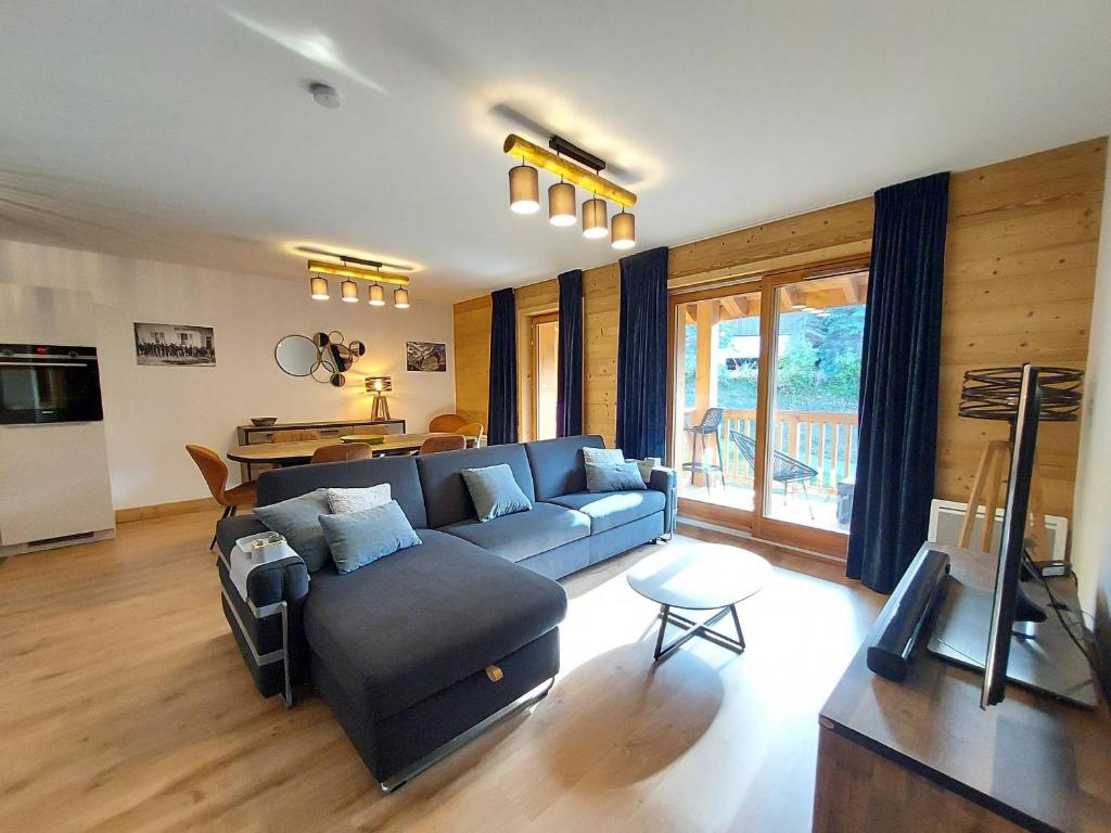 un salon avec un canapé bleu et une table dans l'établissement Superbe Appartement Pied de Pistes pour 7 pers avec Balcon, WIFI et Parking - FR-1-356-495, à Valmorel