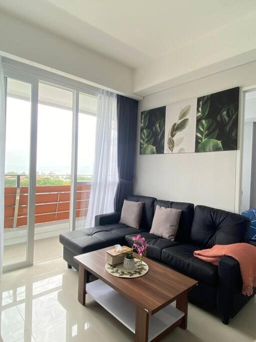 a living room with a black couch and a coffee table at 2 bedroom luxury apartment nongsa golf At The nove Nuvasa Bay in Nongsa