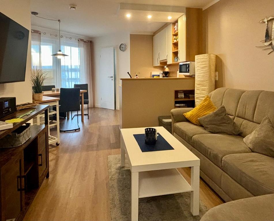 ein Wohnzimmer mit Sofa und Tisch in der Unterkunft Residenz am Yachthafen, Whg 4 in Grömitz