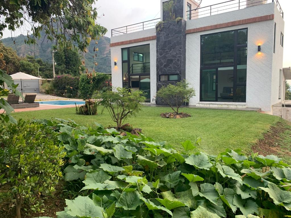 a house with a garden in front of it at Casa Carolina Loft Aryaz in Tepoztlán