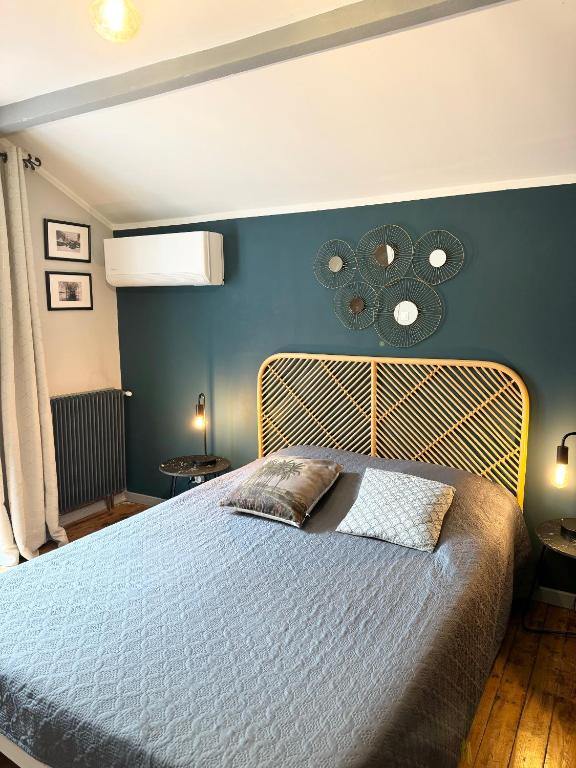 une chambre avec un lit avec un mur bleu dans l'établissement Villa LEONA CLIM PARK, à Bollène