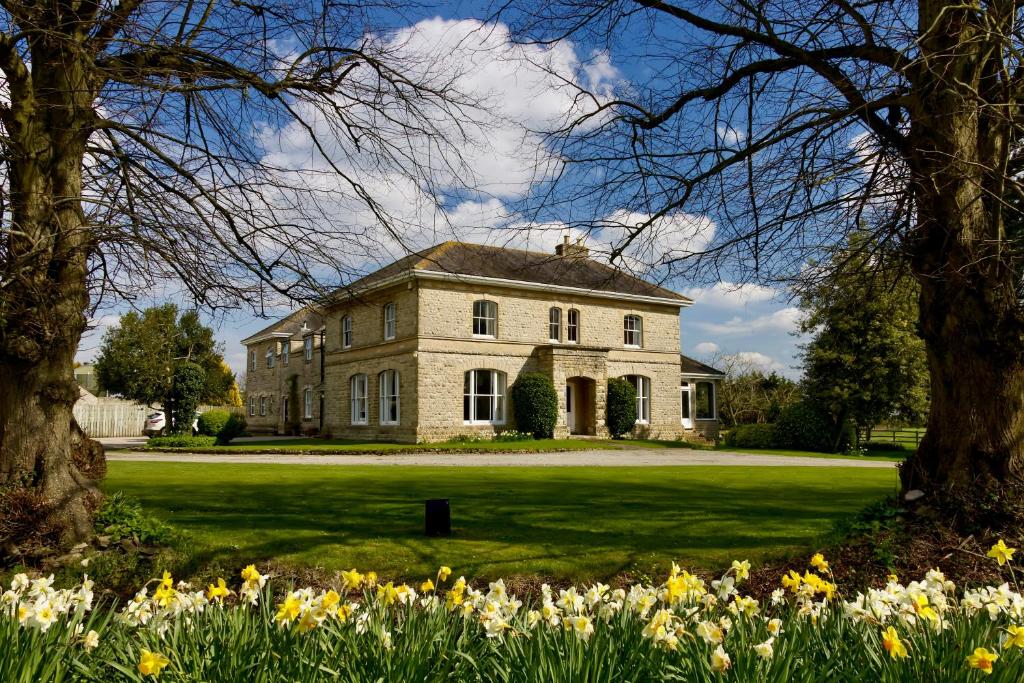 a large house with flowers in front of it at Walltree House in Brackley