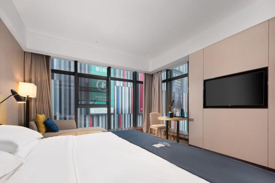 Postel nebo postele na pokoji v ubytování Echarm Hotel Wuhan Optics Valley Software Park Juran Home