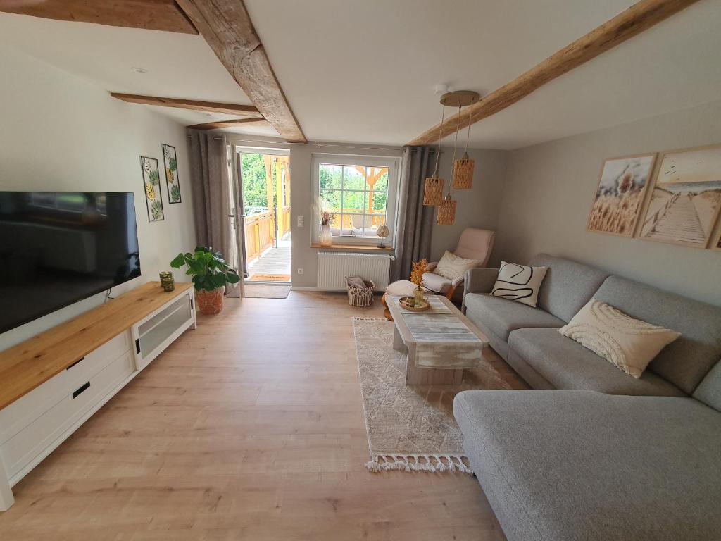 a living room with a couch and a flat screen tv at Ferienwohnung Wesertraum in Lauenförde