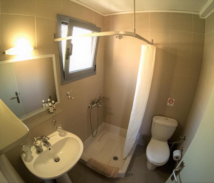 a bathroom with a sink and a toilet and a shower at Domatia me Thea in Elafonisos