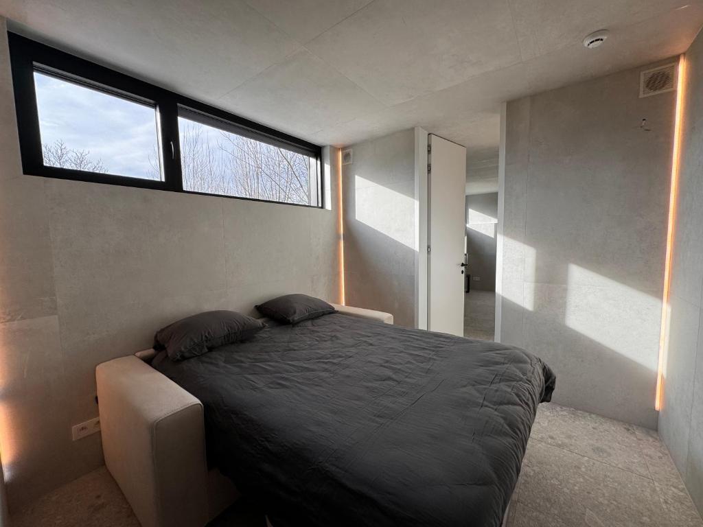 a bedroom with a bed in a room with a window at The Box in Sint-Pieters-Leeuw