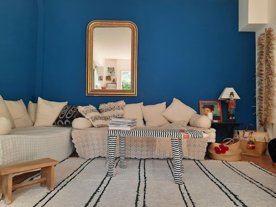 un salon avec un canapé et un miroir dans l'établissement Maison centre Montpellier Jardin et proche plage, à Montpellier