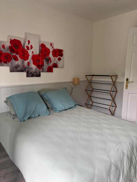 a bedroom with a bed with red flowers on the wall at Un peu de campagne in Saint-Gilles-de-la-Neuville