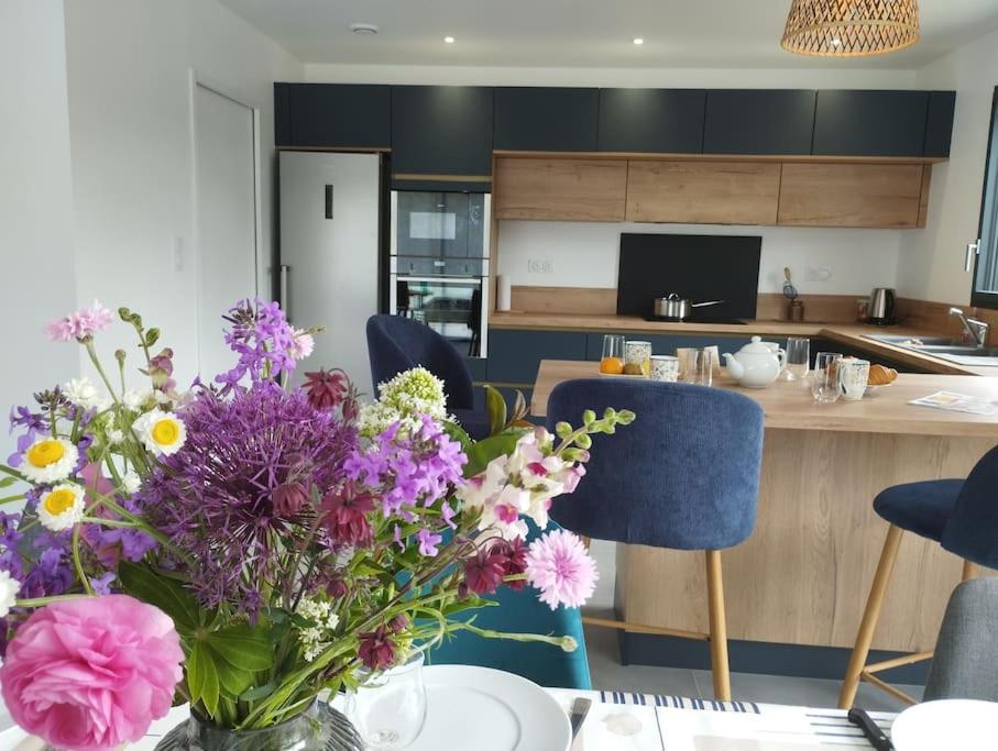 un vase de fleurs sur une table dans une cuisine dans l'établissement Maison familiale, confortable, au coeur du village, à Taulé