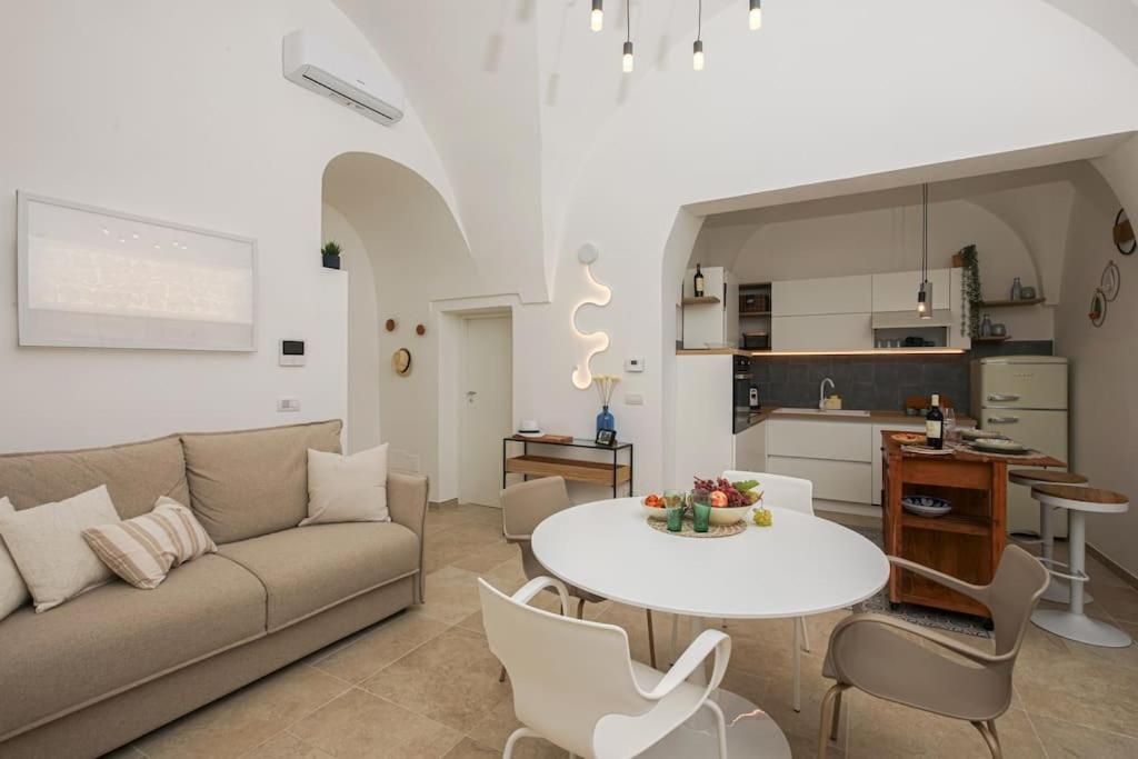 un salon avec un canapé et une table et une cuisine dans l'établissement I ricami di Annina, à Castellana Grotte