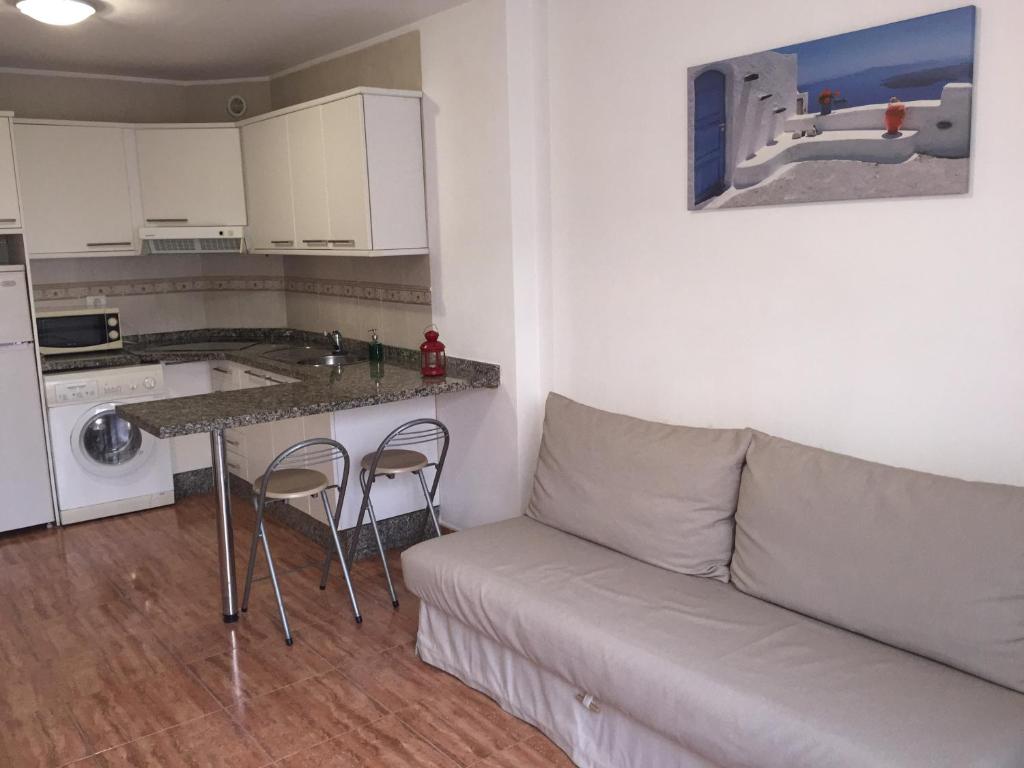 salon z kanapą i stołem oraz kuchnia w obiekcie ViveSur w mieście La Restinga