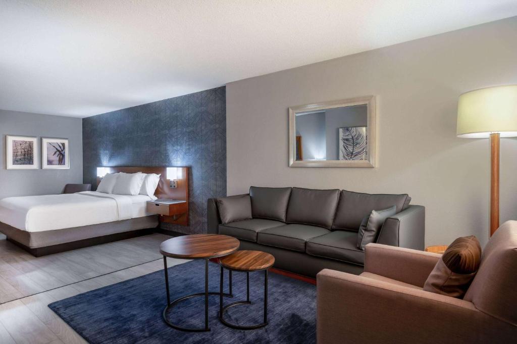 a living room with a couch and a bed at Wyndham Indianapolis Airport in Indianapolis