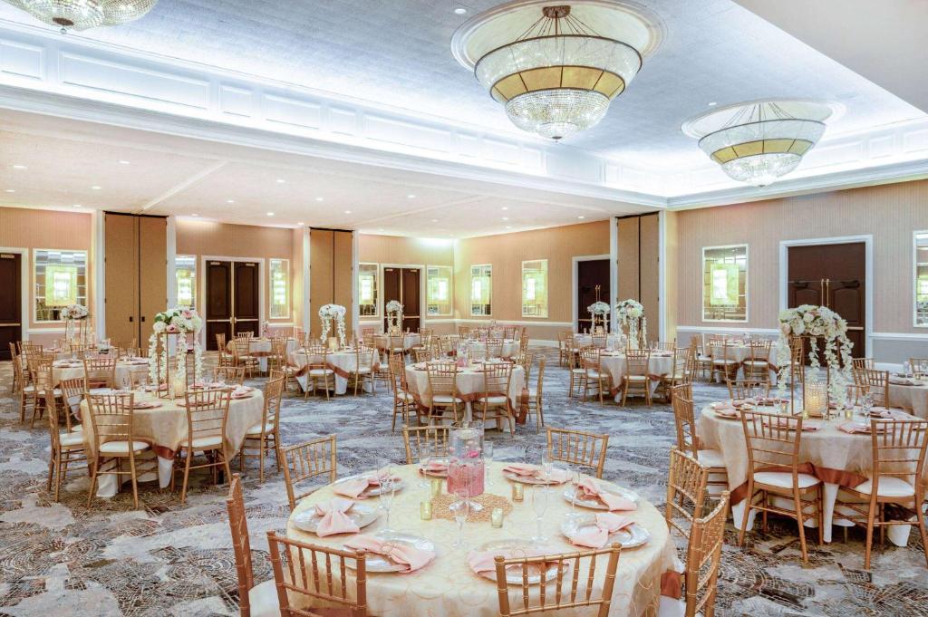 a banquet hall with tables and chairs in a room at Wyndham Indianapolis Airport in Indianapolis