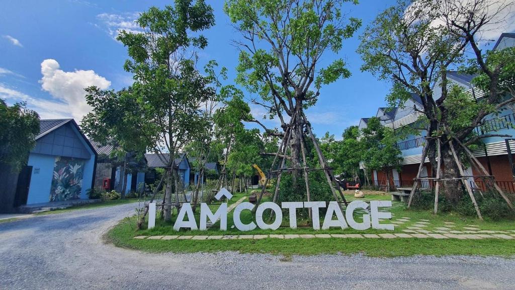 un cartello che recita ingresso di un ufficio in una strada di I AM Cottage เฮือนแก้วมณี a Nakhon Pathom