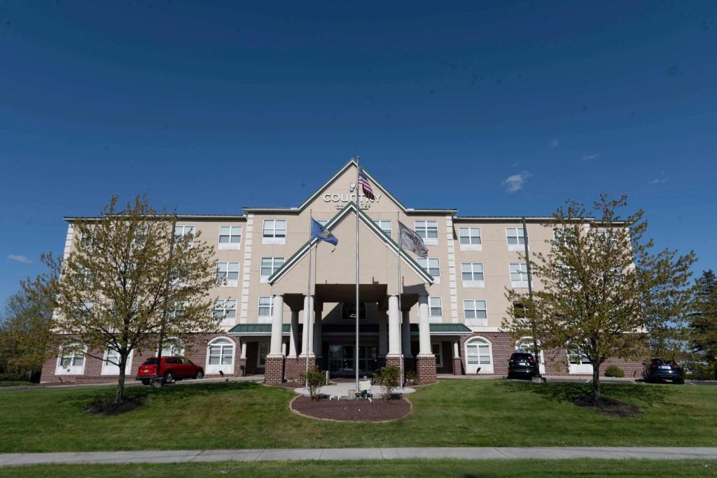 a large building with a clock on the front of it at Country Inn & Suites by Radisson, Harrisburg - Hershey West, PA in Harrisburg