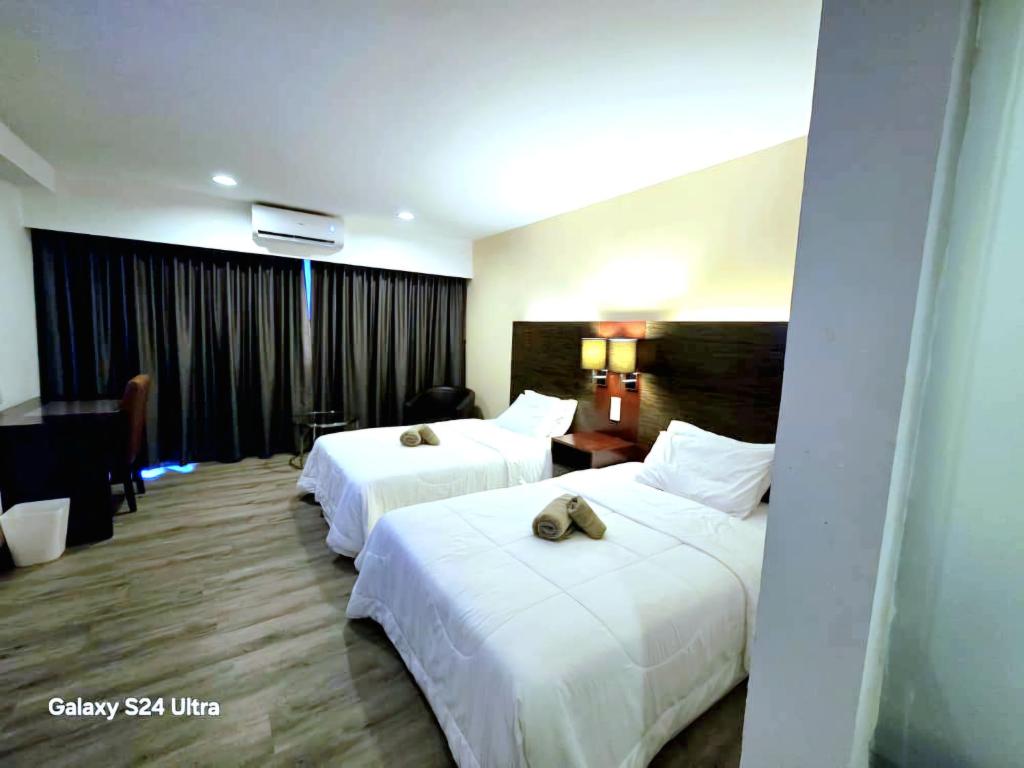 a hotel room with two beds with towels on them at Suites SCSP Residence in Sembulan