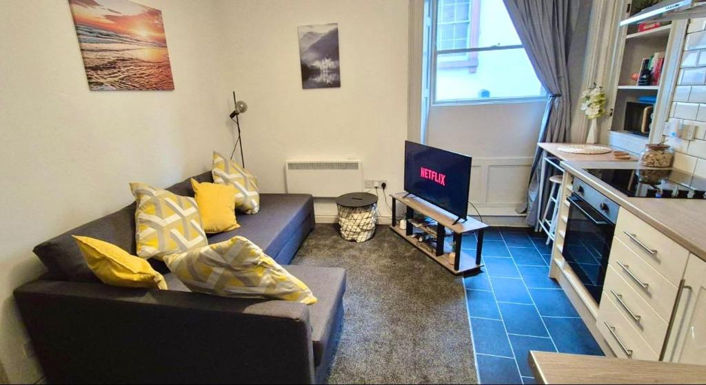 a living room with a couch and a tv at Little Dockray One-Bed Apartment Centre of Penrith in Penrith