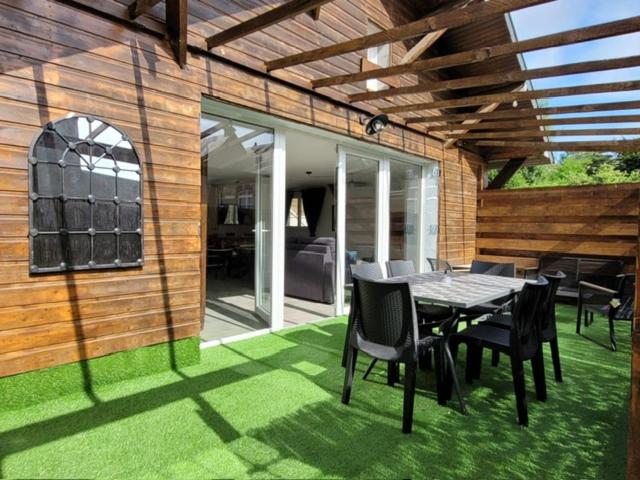 un patio avec une table et des chaises sur l'herbe dans l'établissement Maison bord de mer, à Varaville