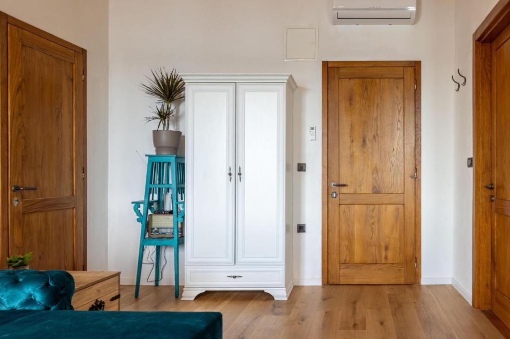 Habitación con armario blanco y silla azul. en Obala apartman, en Biograd na Moru