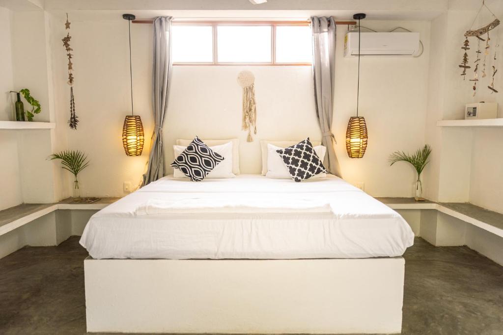 a bedroom with a large white bed with pillows at Casa Coraje in Palomino