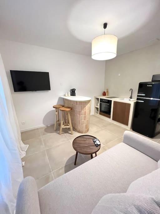 un salon avec un canapé et une cuisine dans l'établissement Appartement avec Jardin et proche plage, à Toulon