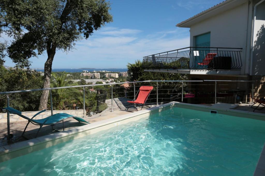 une piscine avec deux chaises sur un balcon dans l'établissement Minoury, à Mandelieu-la-Napoule