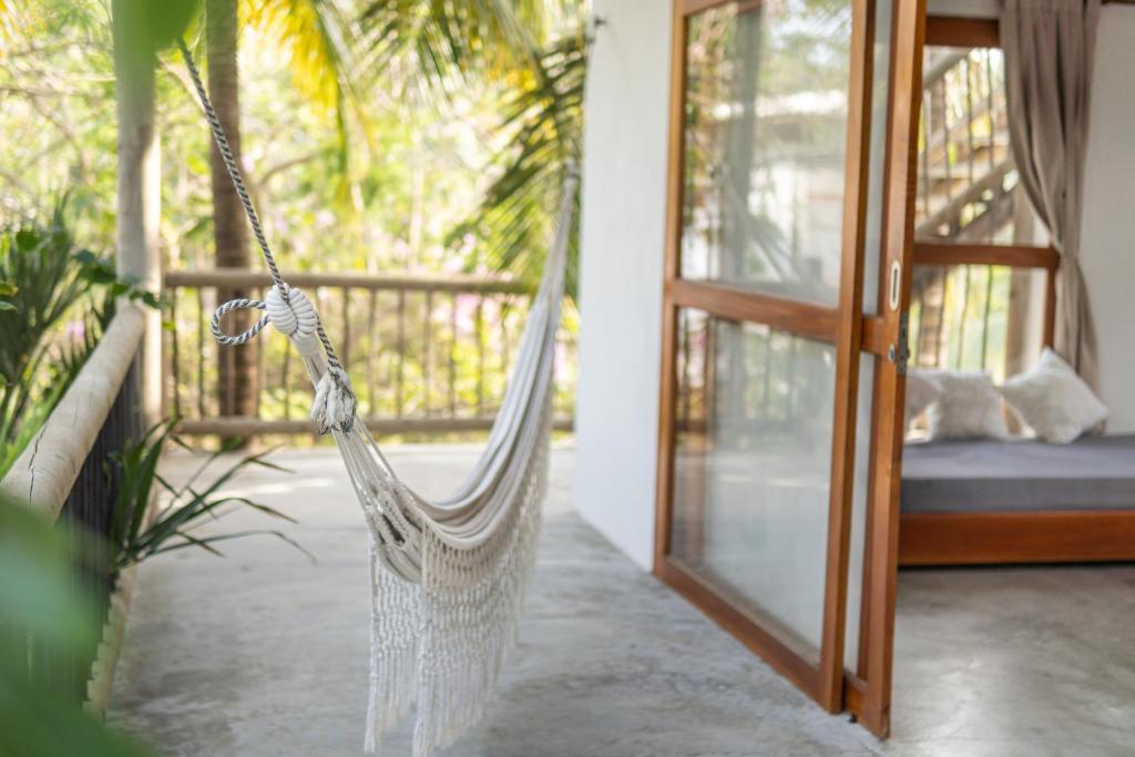 a hammock in a room with a porch at Casa Coraje in Palomino