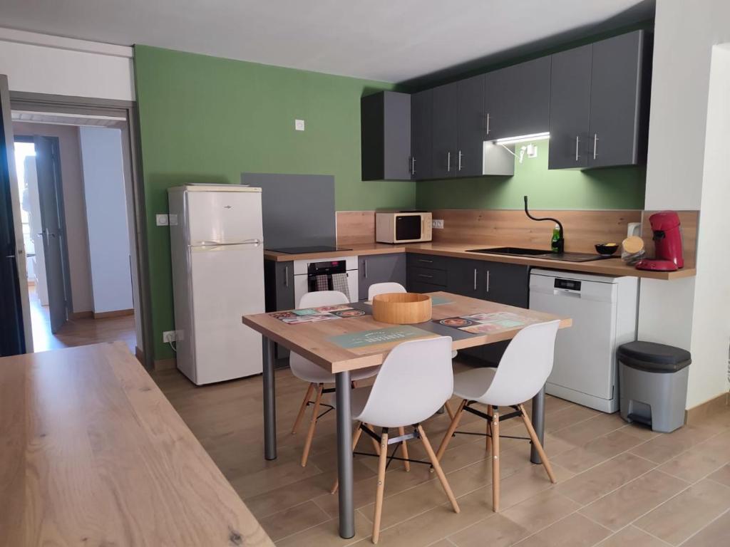 une cuisine avec une table en bois et des appareils électroménagers blancs dans l'établissement Appartement sympathique Saint Nazaire en Royans, à Saint-Nazaire-en-Royans